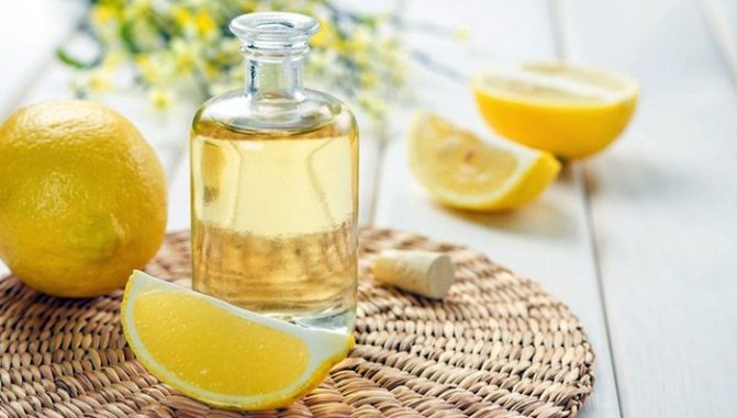 Флакон масла и плоды лимона